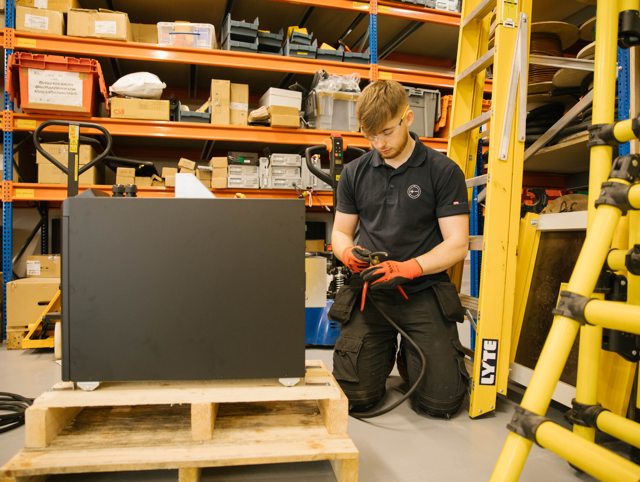Man kneeling whilst working on power source